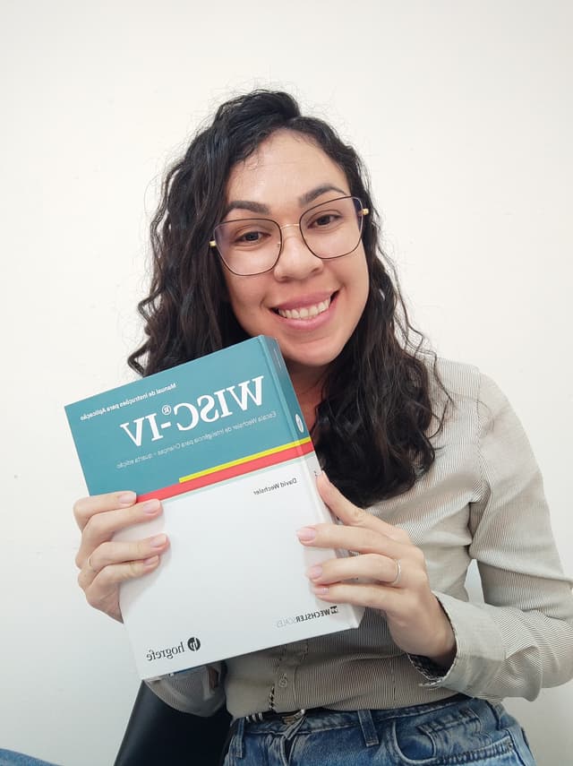 Adaíli Neuropsicóloga segurando o teste Wisc